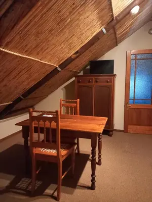a dining room with a wooden table and two chairs at Ongegund Lodge in Somerset West
