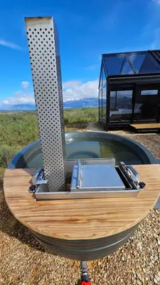 a boat with a sink in front of a house at Little Acre Luxury Pods in Tulbagh