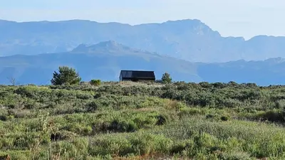 a house on a hill with mountains in the background at Little Acre Luxury Pods in Tulbagh