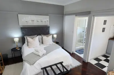 a bedroom with a large bed with two teddy bears on it at Ebenezer in Somerset West