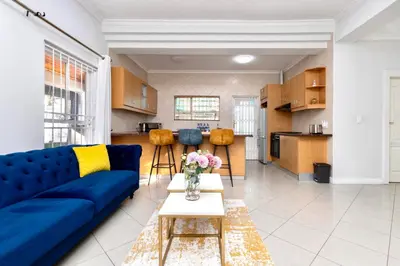 a living room with a blue couch and a table at SERENA INN Apartment no5 in Cape Town