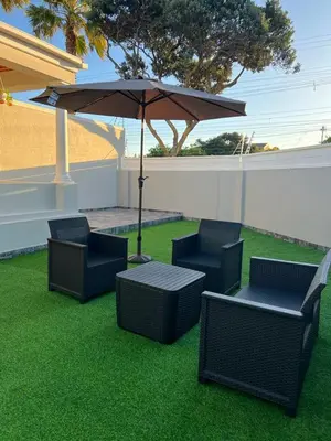 a group of chairs and a table with an umbrella at SERENA INN Apartment no5 in Cape Town