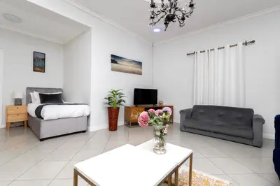 a living room with a couch and a bed at SERENA INN Apartment no5 in Cape Town