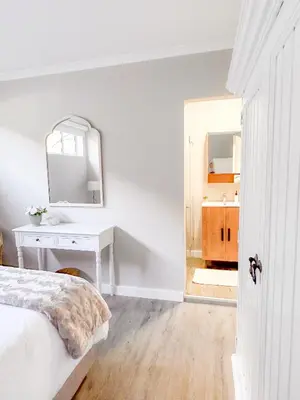 a white bedroom with a white bed and a mirror at Ocean Pearl Hermanus - 5 Bedrooms in Hermanus