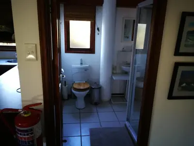 a small bathroom with a toilet and a sink at Paradise Beach House in Clareport