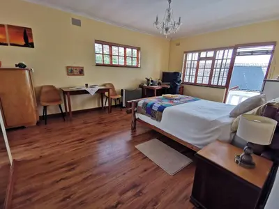 a bedroom with a bed and a table and chairs at Somerset Grace Double en-suit in Somerset West