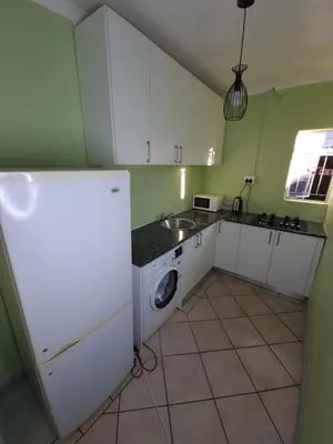 a kitchen with a white refrigerator and a sink at Ojong's Guesthouse Kraaifontein - Eikendel in Cape Town