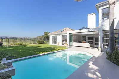 a swimming pool in the backyard of a house at Sunset Spring Villa in Cape Town