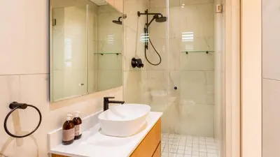 a white bathroom with a sink and a shower at The W-Collection Esplanade Hermanus in Hermanus