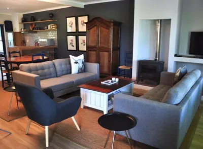 a living room with two couches and a table at Blueberry Hill Cottages in Franschhoek
