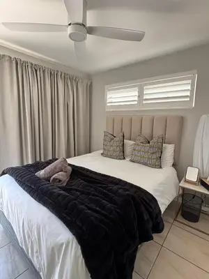 a bedroom with a large bed with a black blanket at Durbanville Self Catering Apartments in Cape Town