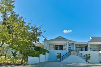 a house with a white fence and stairs at Monte Vidéo Guesthouse in Wellington