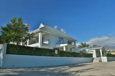a white house with a white fence at Monte Vidéo Guesthouse in Wellington