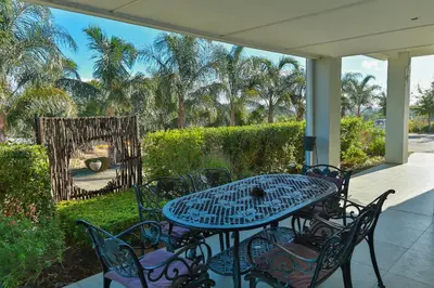 a patio with a table and chairs and a mirror at Monte Vidéo Guesthouse in Wellington