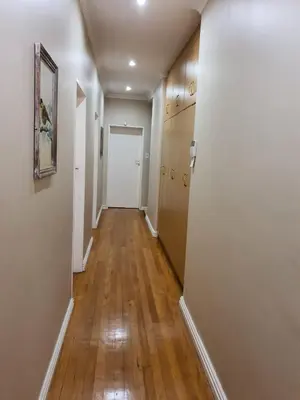 a hallway of an apartment with white walls and wooden floors at Ringwood Villa in Cape Town
