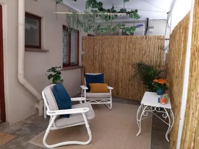 a patio with two chairs and a fence at Villa Vista in Somerset West