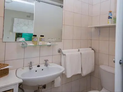 a bathroom with a sink and a toilet and a mirror at Villa Vista in Somerset West