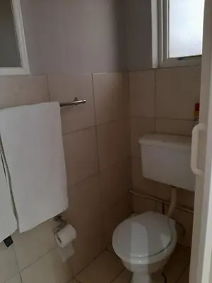 a bathroom with a white toilet and a window at Villa Vista in Somerset West