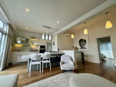 a kitchen and living room with a table and chairs at Tuishuisie in Stellenbosch