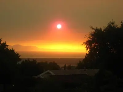 a sunset with the sun in the sky at Mooring House in Somerset West