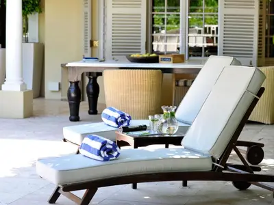 two white chairs and a table in a patio at Auberge Daniella in Franschhoek