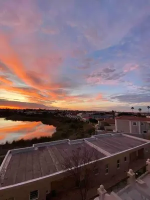 a view of a sunset from a roof of a building at Century On Lake Apartment in Cape Town