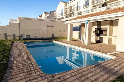a swimming pool in front of a building at Century On Lake Apartment in Cape Town