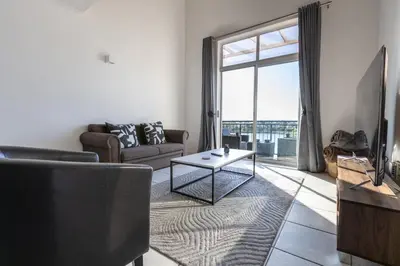 a living room with a couch and a table at Century On Lake Apartment in Cape Town
