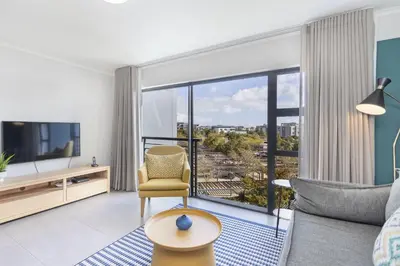 a living room with a couch and a tv at The Terraces 330 by Host Agents in Cape Town