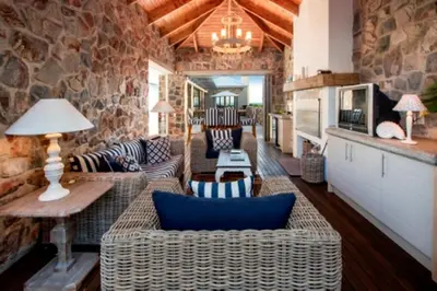a living room with couches and a stone wall at Grandeur in Hermanus