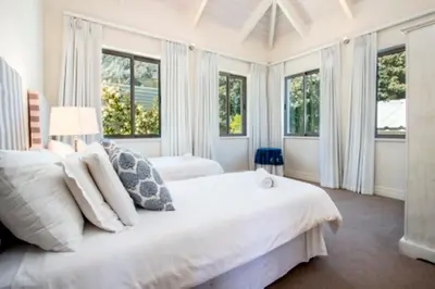 a white bedroom with windows and a large bed at Grandeur in Hermanus