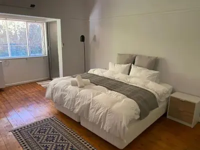 a bedroom with a large white bed with a window at 3 on The Fairway Pinelands in Cape Town
