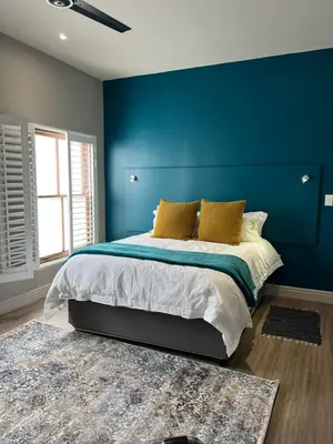 a blue bedroom with a bed and a blue wall at Hermanus Waterfront Apartment no 17 in Hermanus