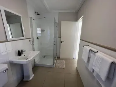 a white bathroom with a shower and a sink at Views galore in Kleinmond in Kleinmond