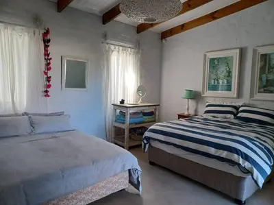 a bedroom with two beds and a chandelier at Chillilabombwe in Pringle Bay