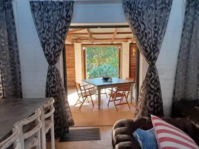 a living room with a table and chairs and a window at Chillilabombwe in Pringle Bay
