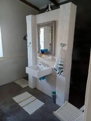 a bathroom with a sink and a mirror at Chillilabombwe in Pringle Bay