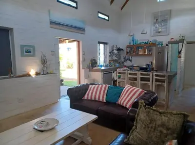 a living room with a couch and a table at Chillilabombwe in Pringle Bay