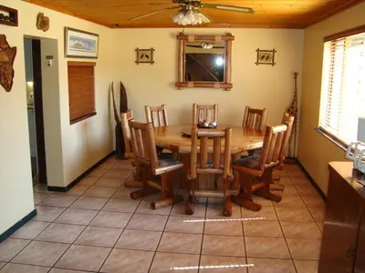 a dining room with a wooden table and chairs at Pentzhaven Guesthouse in Table View