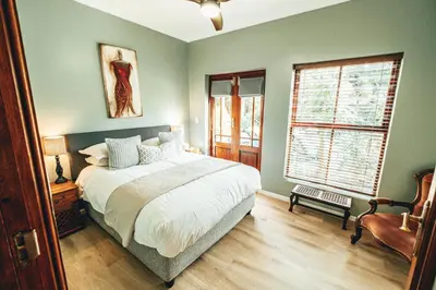 a bedroom with a large bed and a window at Villa Chad Luxury Guesthouse in Kleinmond