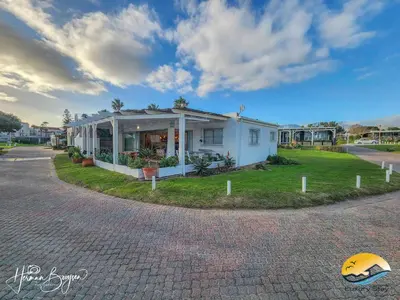 a small white house on the side of a road at Seaside Charm in Gordonʼs Bay