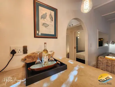 a room with a counter with two bottles of wine on it at Seaside Charm in Gordonʼs Bay