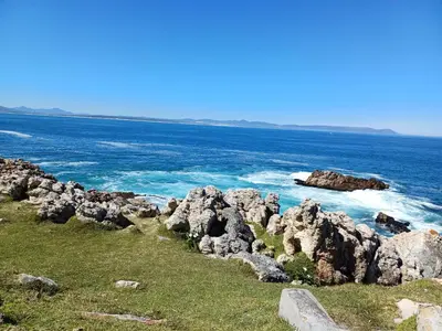 a group of rocks on the shore of the ocean at Dukes Place in Hermanus
