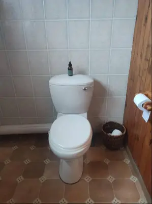a bathroom with a toilet with a bottle on top of it at Dukes Place in Hermanus