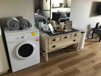 a living room with a washing machine and a table at Blouberg Studio in Cape Town