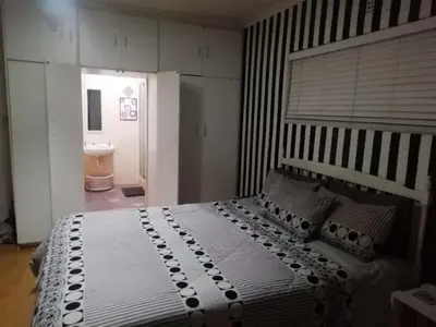 a bedroom with a large bed and a bathroom at 11 on Orange in Cape Town