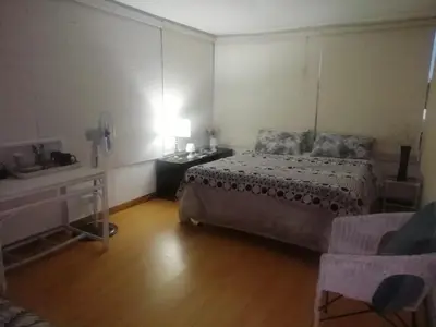 a bedroom with a bed and a table and a lamp at 11 on Orange in Cape Town