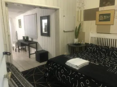 a bedroom with a black bed and a table at 11 on Orange in Cape Town