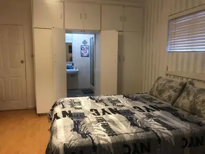 a bedroom with a bed and a bathroom with a sink at 11 on Orange in Cape Town