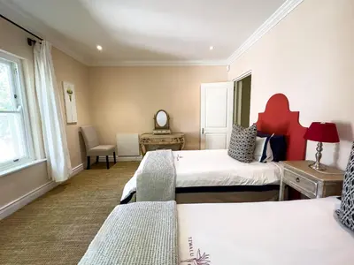 a hotel room with two beds and a window at The hidden Retreat on Haumann in Franschhoek